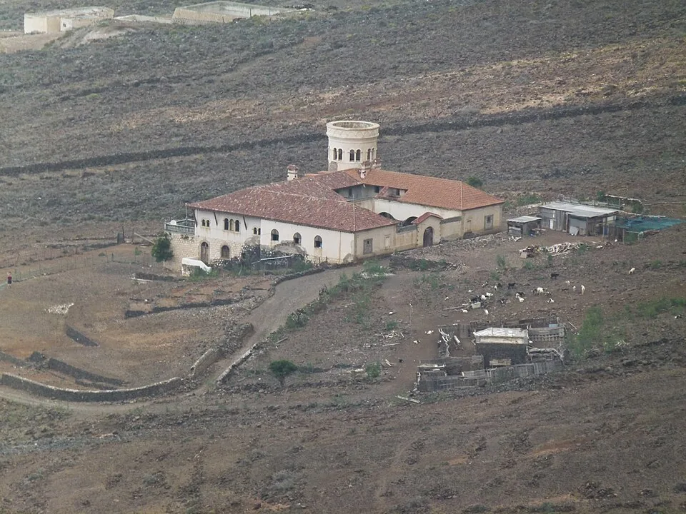 The isolated stone house of Villa Winter with its round corner tower below the mountains at Cofete, Fuerteventura