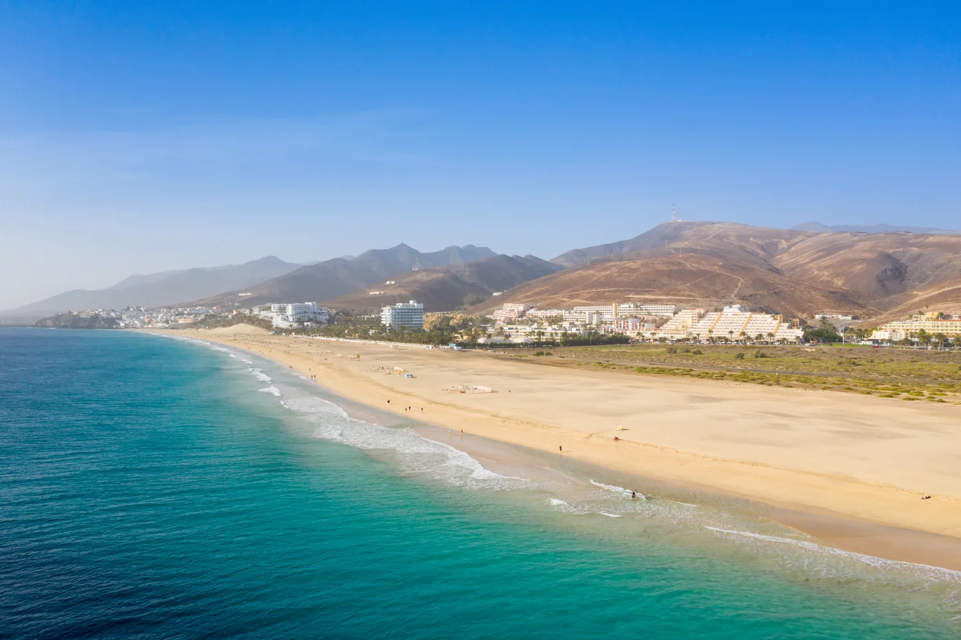 Expansive golden sands of Playa del Matorral in Morro Jable, featuring a lifeguard tower and tranquil turquoise waters.