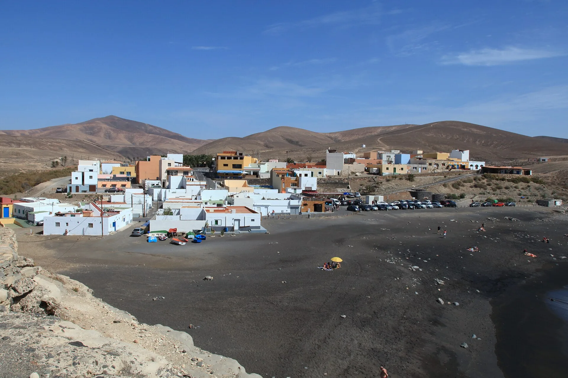 Black volcanic sand beach at Ajuy, Fuerteventura, with steep cliffs and the entrance to the Caleta Negra caves