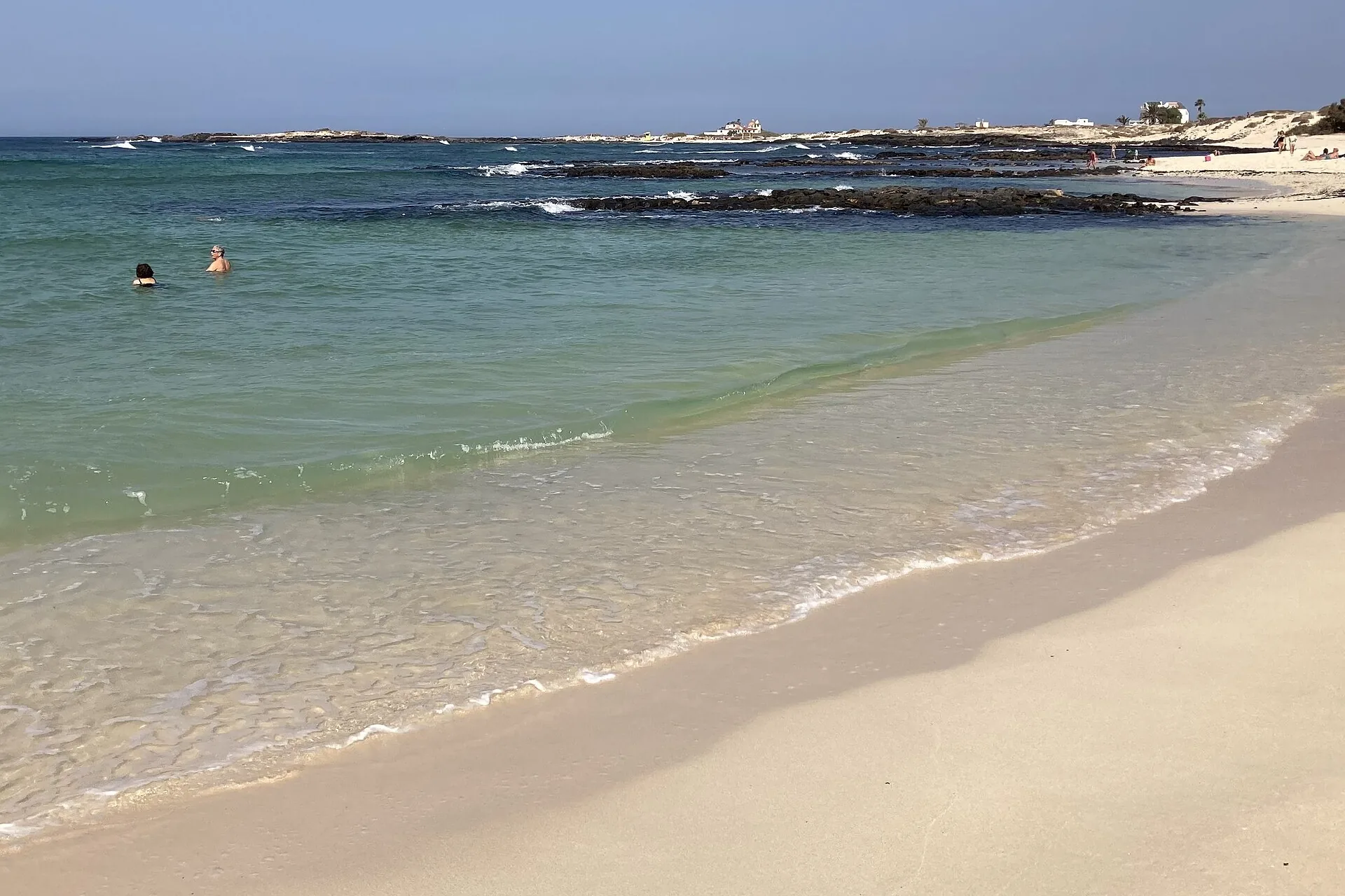 Calm turquoise lagoon at Playa de la Concha, El Cotillo, enclosed by a horseshoe-shaped volcanic reef