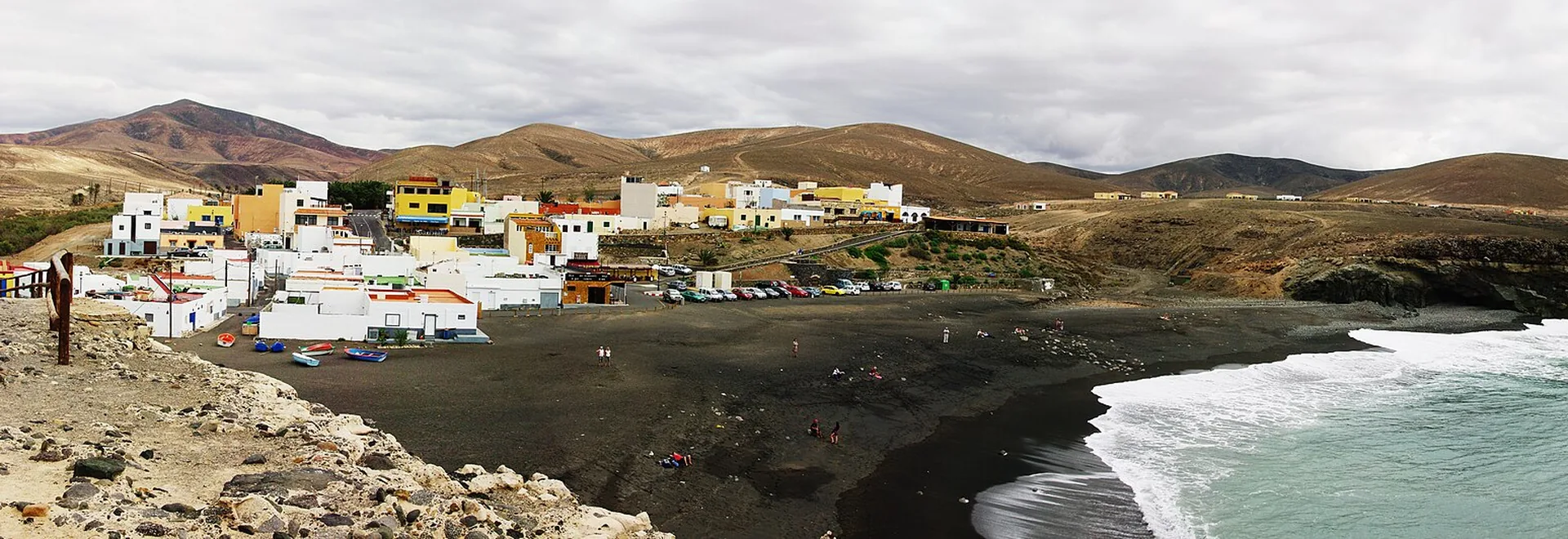 Black volcanic sand beach at Ajuy, Fuerteventura, with steep cliffs and the entrance to the Caleta Negra caves