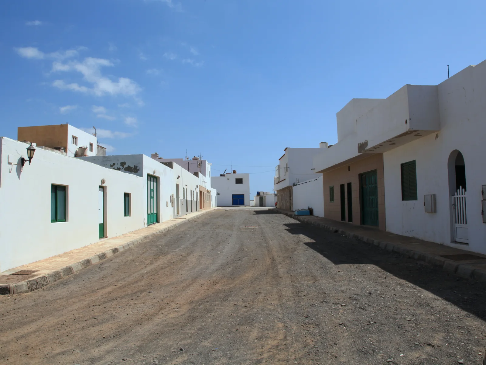 A quiet unpaved street of whitewashed, single-storey fishing houses in the hamlet of El Puertito
