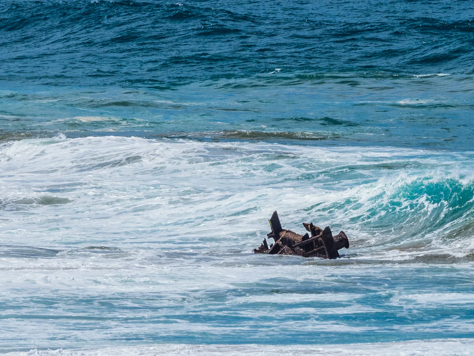 The rusted remains of the SS American Star shipwreck in the surf at Playa de Garcey