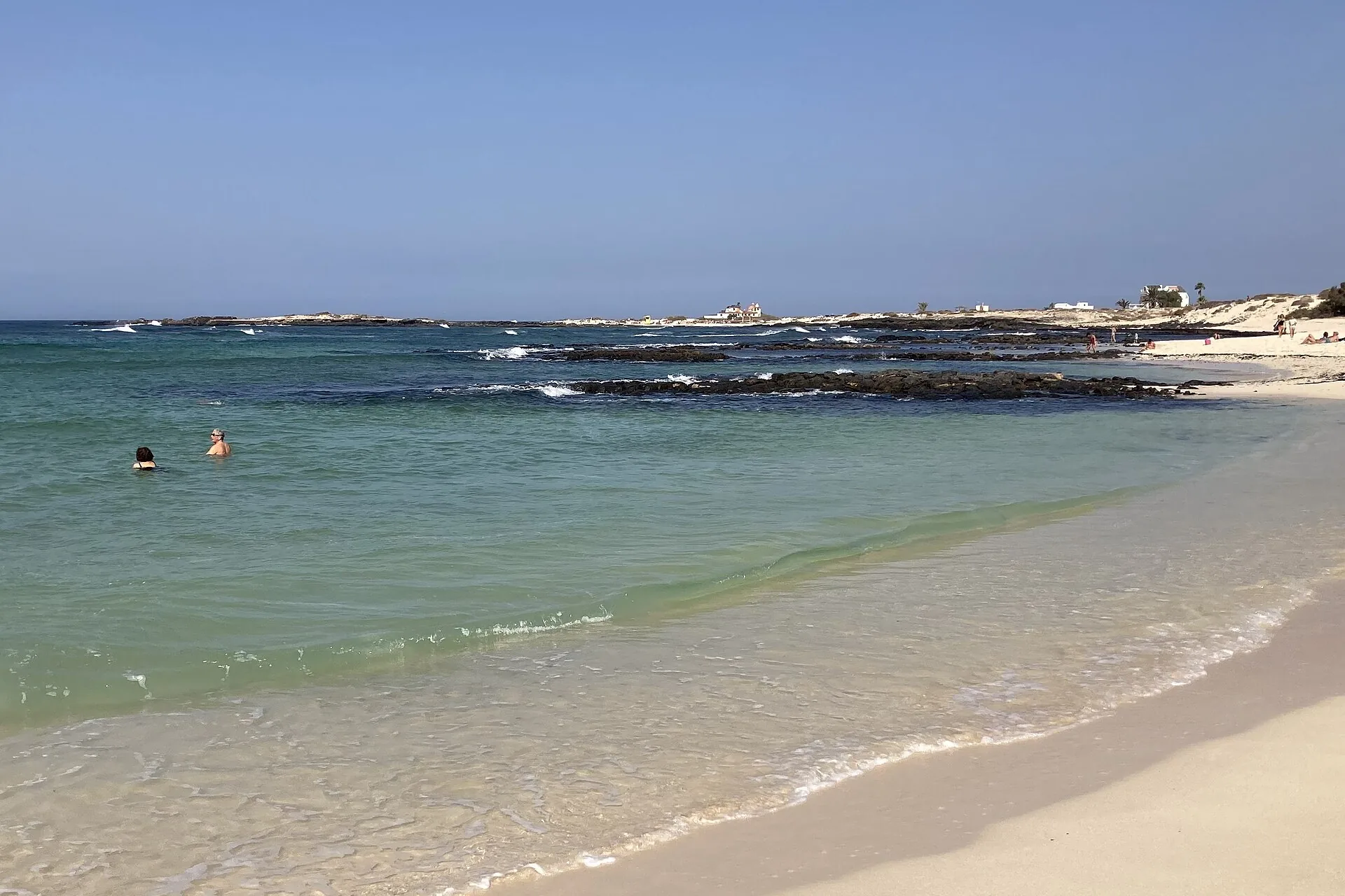 Calm turquoise lagoon at Playa de la Concha, El Cotillo, enclosed by a horseshoe-shaped volcanic reef